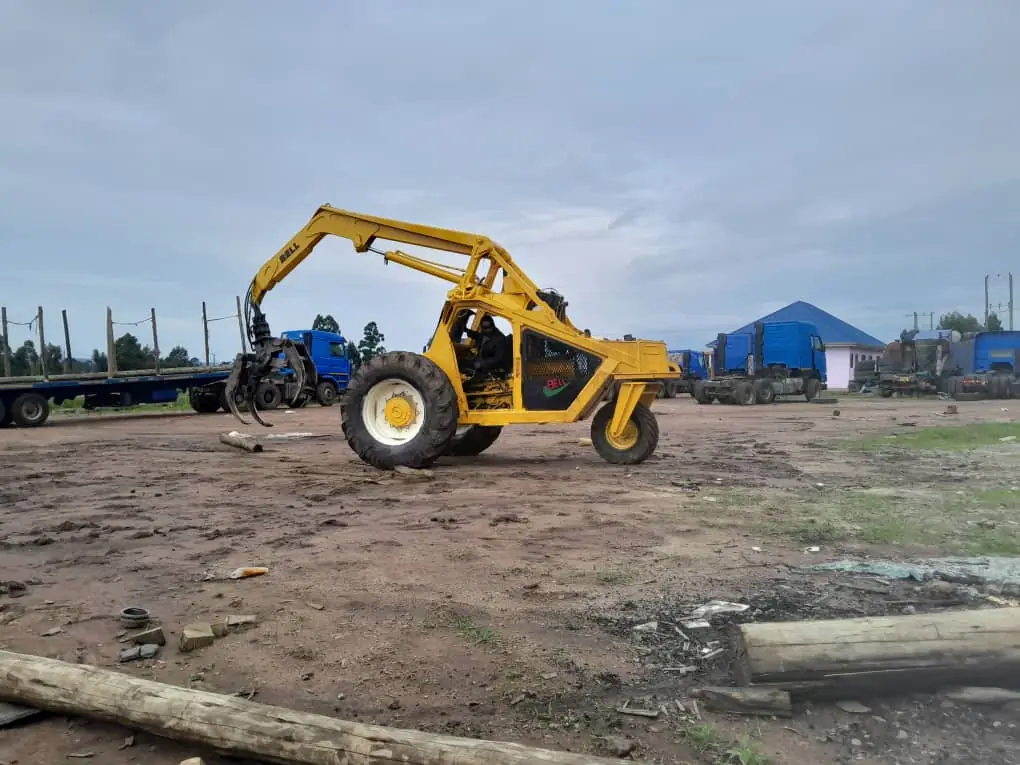 Loader handling poles in the yard